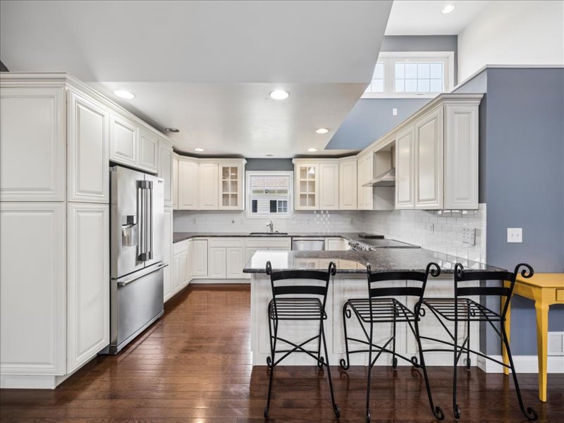 Kitchen with white cabinetry, island seating and stainless appliances at 134 Salt Creek Drive, Dover, Delaware
