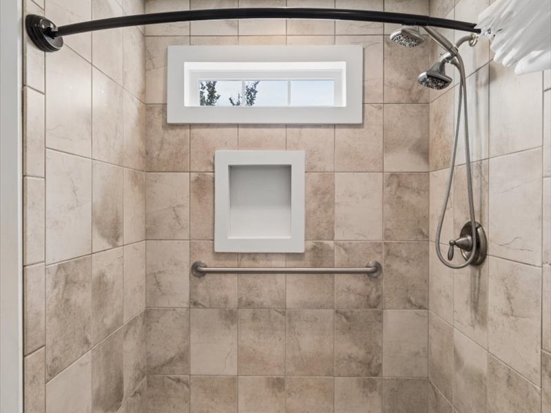 Tiled walk-in shower with bench and grab bar at 134 Salt Creek Drive, Dover, Delaware