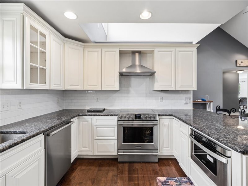 Kitchen with skylight, range hood and granite counters at 134 Salt Creek Drive, Dover, Delaware