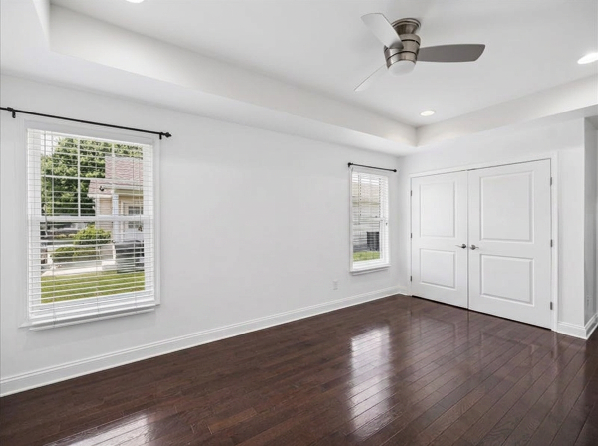 Spacious primary bedroom with tray ceiling, dark hardwood floors and double closet at 134 Salt Creek Drive, Dover, Delaware